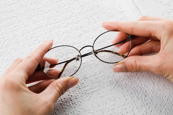 Kvinna Håller Svart Rimmade Glasögon Mot Bakgrund Öppen Lärobok Läsa — Stockfoto