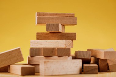 Jenga modeliyle girişimci riski kavramı. Sarı arka planda tahta bloklar