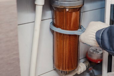 Su filtresi - tesisatçı kirli su filtresini değiştirir. Musluk suyunun temizlenmesi.