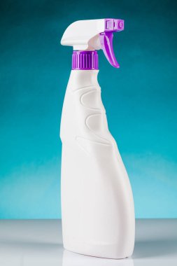 Sprey tabancayı temizlemek için plastik şişe. Mavi bir arkaplanda.