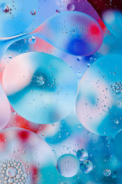 Крупный план движения капель масла по поверхности воды. Красочный абстрактный макрофон масляных капель на поверхности воды