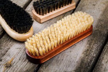 Ahşap bir masadaki ayakkabıların bakım ve temizliği için aksesuarlar..