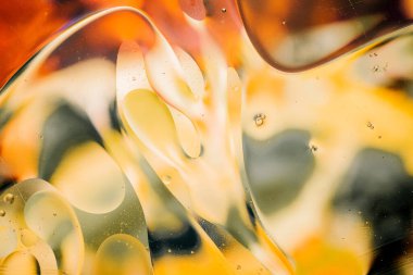 Su yüzeyindeki yağ damlacıklarının hareketine yakın çekim. Su yüzeyindeki yağ damlalarının renkli ve soyut makro arkaplanı