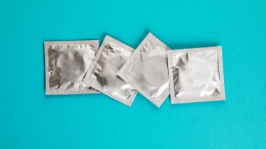 Mavi arka planda prezervatif. Güvenli seks kavramı