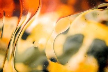 Su yüzeyindeki yağ damlacıklarının hareketine yakın çekim. Su yüzeyindeki yağ damlalarının renkli ve soyut makro arkaplanı