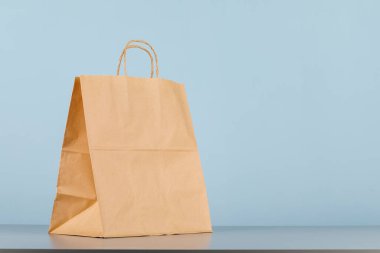Kese kağıdının saplı hali, logo veya tasarım için alanı olan boş alışveriş çantası, yemek teslimatı konsepti.
