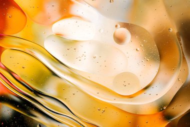 Su yüzeyindeki yağ damlacıklarının hareketine yakın çekim. Su yüzeyindeki yağ damlalarının renkli ve soyut makro arkaplanı