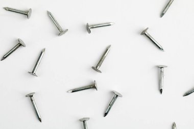 Metal çiviler yakın, beyaz arka planda bir sürü çivi var.