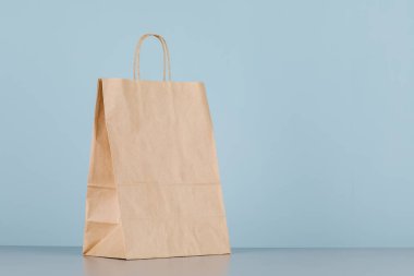 Kese kağıdının saplı hali, logo veya tasarım için alanı olan boş alışveriş çantası, yemek teslimatı konsepti.