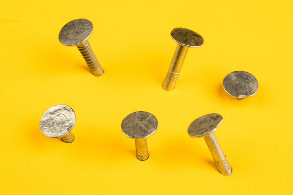 Металлические гвозди крупным планом, много гвоздей на желтом фоне