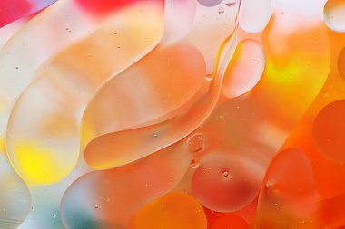 Su yüzeyindeki yağ damlacıklarının hareketine yakın çekim. Su yüzeyindeki yağ damlalarının renkli ve soyut makro arkaplanı