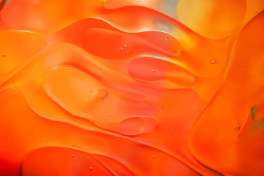 Su yüzeyindeki yağ damlacıklarının hareketine yakın çekim. Su yüzeyindeki yağ damlalarının renkli ve soyut makro arkaplanı