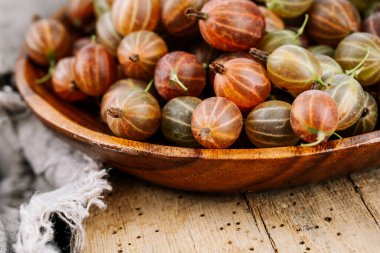 Ahşap bir masada kırmızı bektaşi üzümü