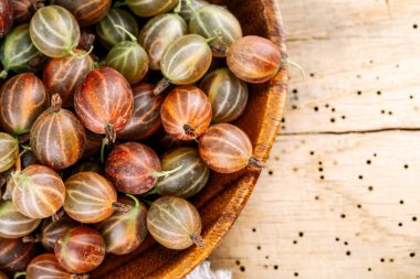 Ahşap bir masada kırmızı bektaşi üzümü