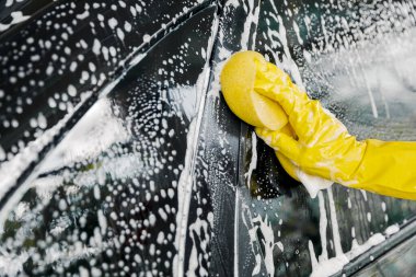 Sarı süngerli bir kadın eli yıkamak, araba yıkamak için..