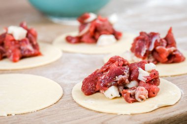 Bir adam khinkali 'yi yakın planda tutuyor. Mutfakta yemek pişir. Ulusal bir yemek hazırlama süreci