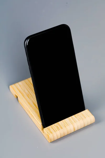 Teléfono Inteligente Negro Soporte Madera Está Acostado Sobre Mesa Lugar — Foto de Stock
