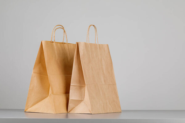 Brown paper bag with handles, empty shopping bag with area for your logo or design, food delivery concept