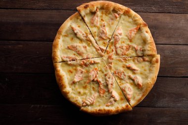 Tahta arka planda somonlu pizza. Lezzetli yemek konsepti.