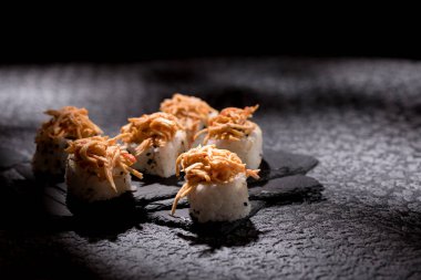 Siyah bir arka planda iştah açıcı börekler. Japon yemeği konsepti. Yakın plan..