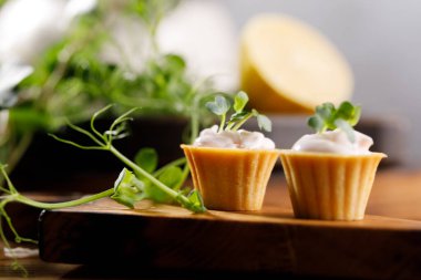 Hafif kremalı kanepeler. Mikro yeşilliklerle hayat. Aperatif atıştırmalık konsepti. Yakın plan.