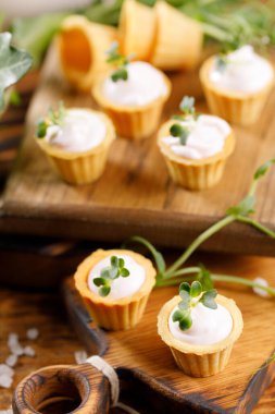 Hafif kremalı kanepeler. Mikro yeşilliklerle hayat. Aperatif atıştırmalık konsepti. Yakın plan.