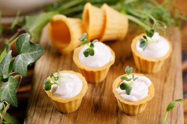 Hafif kremalı kanepeler. Mikro yeşilliklerle hayat. Aperatif atıştırmalık konsepti. Yakın plan.