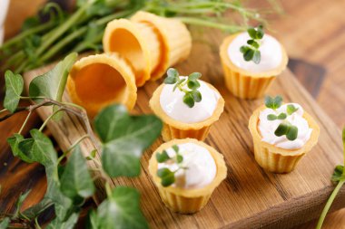 Hafif kremalı kanepeler. Mikro yeşilliklerle hayat. Aperatif atıştırmalık konsepti. Yakın plan.