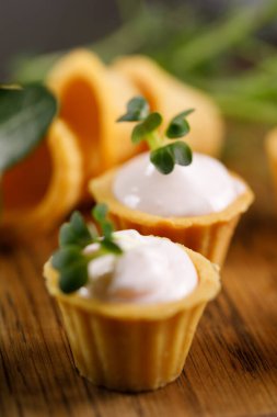 Hafif kremalı kanepeler. Mikro yeşilliklerle hayat. Aperatif atıştırmalık konsepti. Yakın plan.