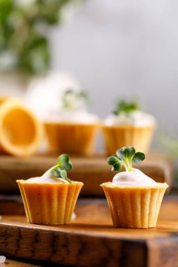 Hafif kremalı kanepeler. Mikro yeşilliklerle hayat. Aperatif atıştırmalık konsepti. Yakın plan.