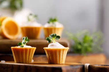 Hafif kremalı kanepeler. Mikro yeşilliklerle hayat. Aperatif atıştırmalık konsepti. Yakın plan.