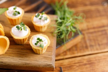 Hafif kremalı kanepeler. Mikro yeşilliklerle hayat. Aperatif atıştırmalık konsepti. Yakın plan.