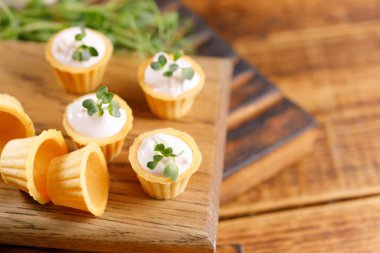 Hafif kremalı kanepeler. Mikro yeşilliklerle hayat. Aperatif atıştırmalık konsepti. Yakın plan.