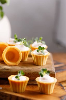 Hafif kremalı kanepeler. Mikro yeşilliklerle hayat. Aperatif atıştırmalık konsepti. Yakın plan.