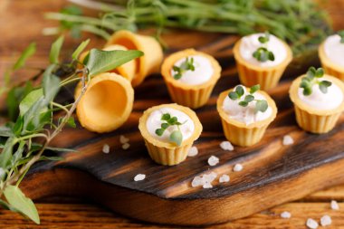 Hafif kremalı kanepeler. Mikro yeşilliklerle hayat. Aperatif atıştırmalık konsepti. Yakın plan.