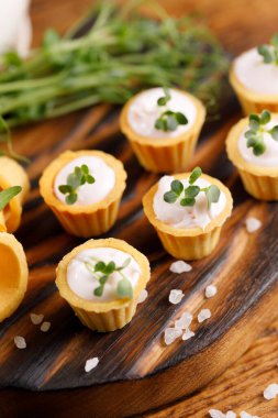 Hafif kremalı kanepeler. Mikro yeşilliklerle hayat. Aperatif atıştırmalık konsepti. Yakın plan.