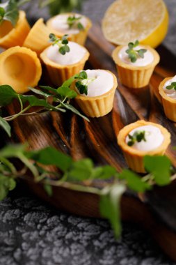 Hafif kremalı kanepeler. Mikro yeşilliklerle hayat. Aperatif atıştırmalık konsepti. Yakın plan.