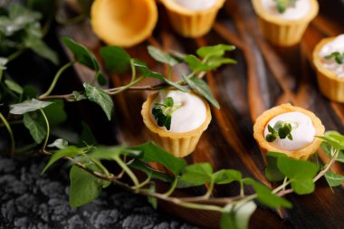 Hafif kremalı kanepeler. Mikro yeşilliklerle hayat. Aperatif atıştırmalık konsepti. Yakın plan.