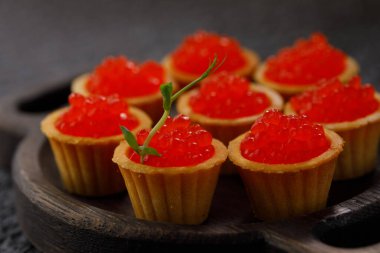 Dekoratif panoda servis için kırmızı havyarlı iştah açıcı tartlar. Tatil kavramı.