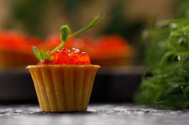 Dekoratif panoda servis için kırmızı havyarlı iştah açıcı tartlar. Tatil kavramı.