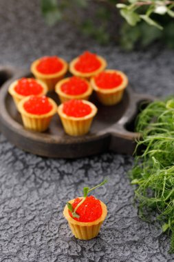 Kırmızı havyarlı ve mikroyeşil desenli iştah açıcı tartlar. Tatil kavramı.