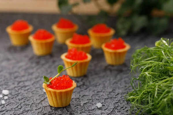 Kırmızı havyarlı ve mikroyeşil desenli iştah açıcı tartlar. Tatil kavramı.