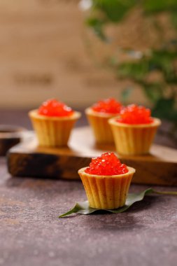 Dekoratif panoda servis için kırmızı havyarlı iştah açıcı tartlar. Tatil kavramı.