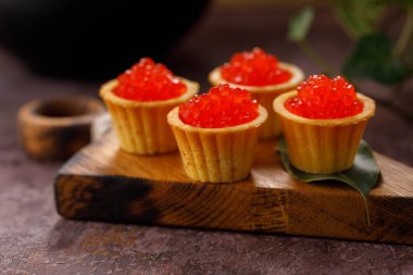 Dekoratif panoda servis için kırmızı havyarlı iştah açıcı tartlar. Tatil kavramı.