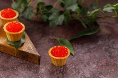 Dekoratif panoda servis için kırmızı havyarlı iştah açıcı tartlar. Tatil kavramı.