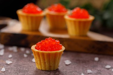 Dekoratif panoda servis için kırmızı havyarlı iştah açıcı tartlar. Tatil kavramı.