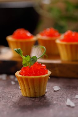Dekoratif panoda servis için kırmızı havyarlı iştah açıcı tartlar. Tatil kavramı.