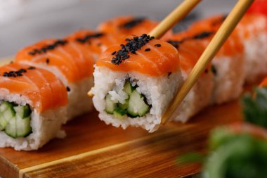 Salatalıklı Philadelphia dürümü ve somon ve ton balıklı suşi. Suşi menüsü. Japon yemeği. Yakın plan..