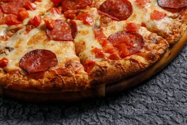Siyah desenli arka planda Pepperoni pizza. İtalyan gıda konsepti.