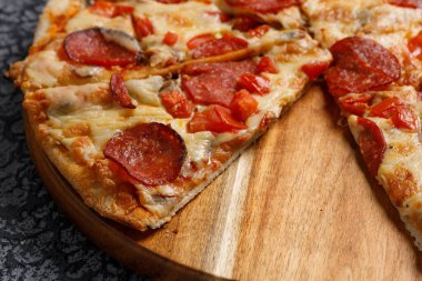 Siyah desenli arka planda Pepperoni pizza. İtalyan gıda konsepti.